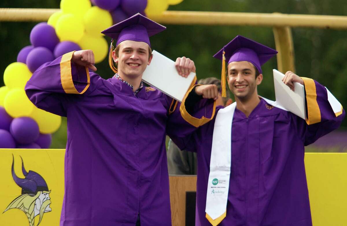 Graduates Greyson Miller, left, and Nathaniel Yaghoubian do a flex pose after getting thier diplomas during Westhill High School's Graduation in Stamford, Conn., on Friday June 18, 2021.