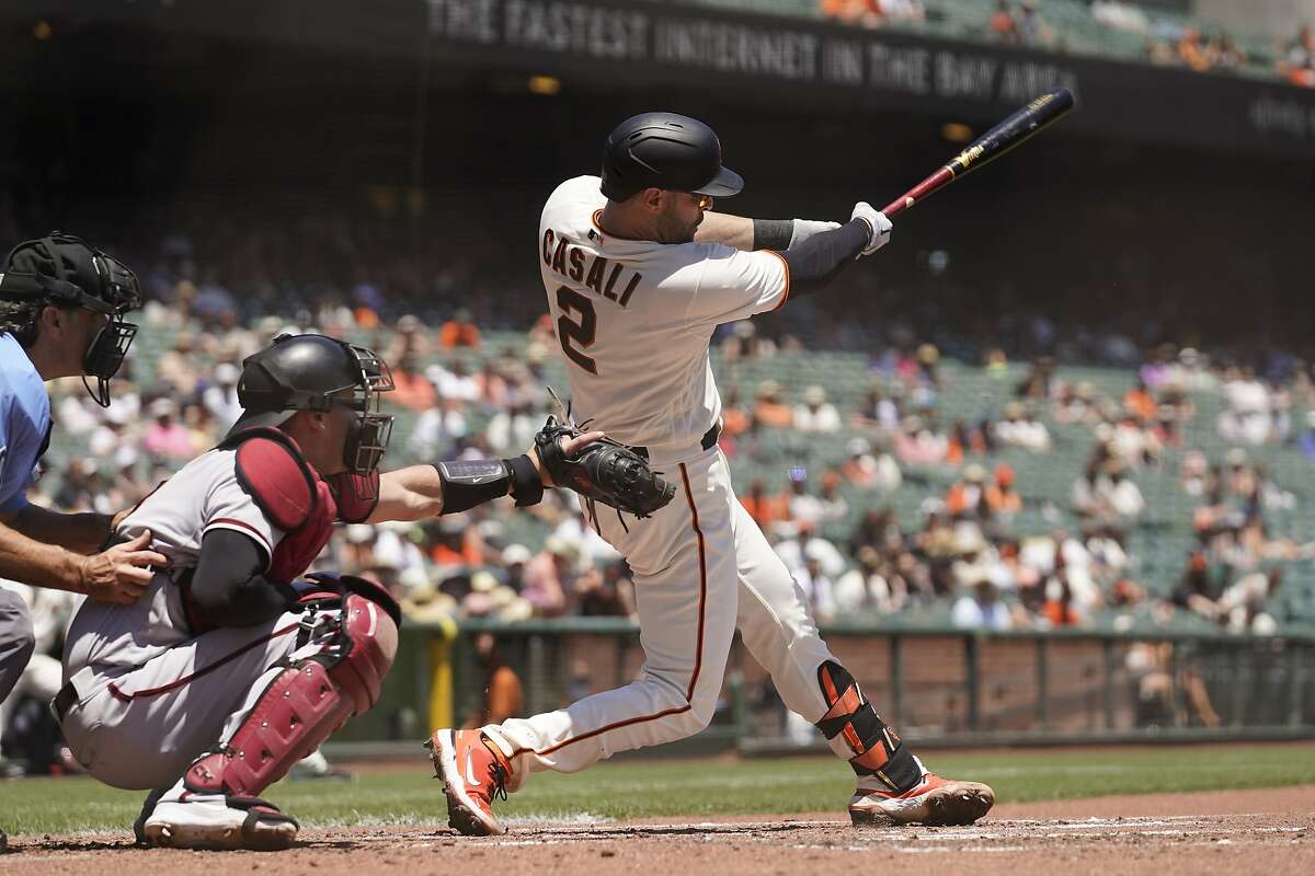 San Francisco Giants' Curt Casali, right, hits a two-run home run off Arizona Diamondbacks starting pitcher Zac Gallen in the second inning of a baseball game Thursday, June 17, 2021, in San Francisco. Diamondbacks catcher Carson Kelly, center, and home plate umpire Phil Cuzzi, left, look on. (AP Photo/Eric Risberg)
