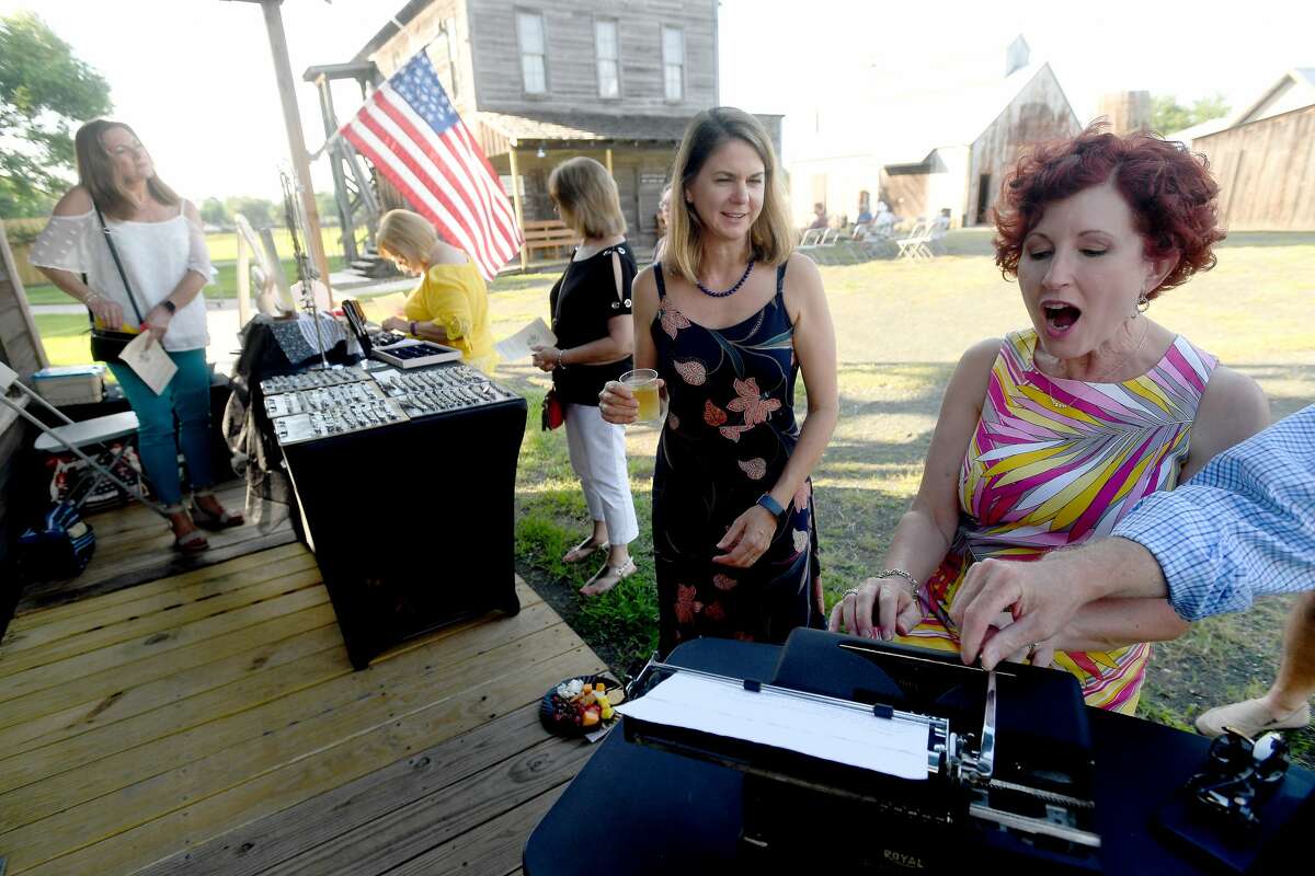 Lori Wenner reacts as she gets an old school typing lesson as she and friends, including Rebecca Boone, take in Andrea Beck's typewriter jewelry booth while attending wine and jazz night at the Spindletop-Gladys City Boomtown Museum Friday. Photo made Friday, June 18, 2021 Kim Brent/The Enterprise