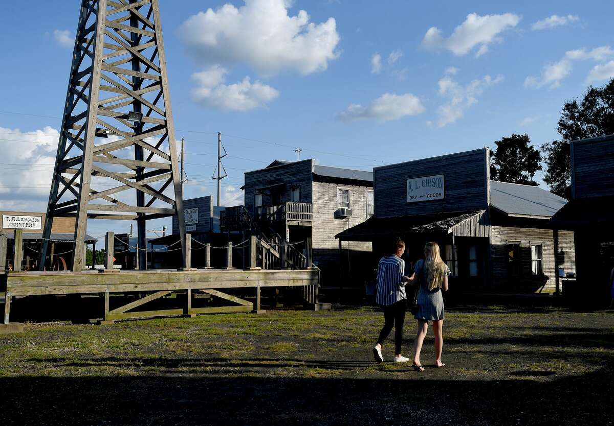 Friends stroll through the grounds as Seth Wade Melancon performs while they enjoy a night of wine and jazz at the Spindletop-Gladys City Boomtown Museum Friday. Photo made Friday, June 18, 2021 Kim Brent/The Enterprise