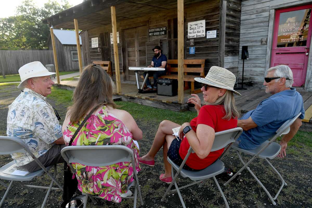 Friends socialize as Seth Wade Melancon performs while they enjoy a night of wine and jazz at the Spindletop-Gladys City Boomtown Museum Friday. Photo made Friday, June 18, 2021 Kim Brent/The Enterprise