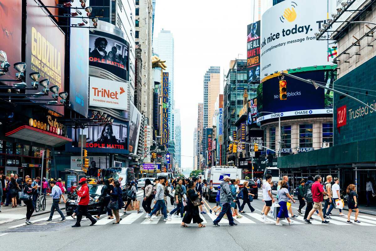 Una multitud bulliciosa cruza una intersección en la ciudad de Nueva York.