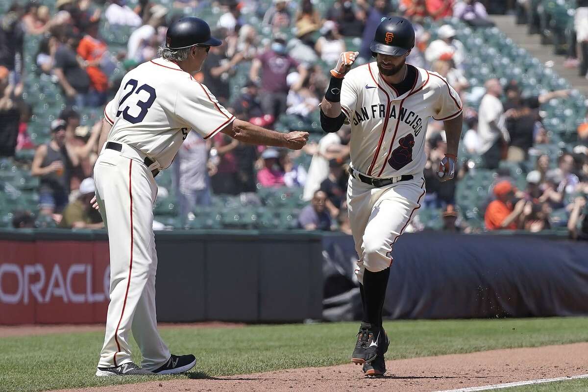 San Francisco Giants' Brandon Belt, right, is congratulated by third base coach Ron Wotus after hitting a home run against the Philadelphia Phillies during the third inning of a baseball game in San Francisco, Saturday, June 19, 2021. (AP Photo/Jeff Chiu)