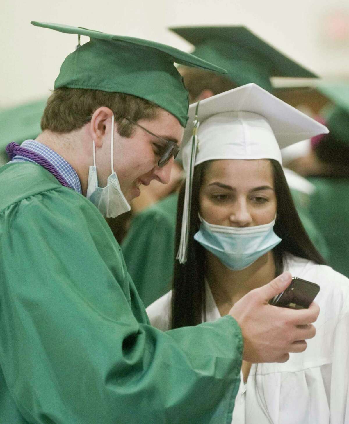 Daniel Rizvic and Thea Spinner check out a phone photo prior to the start of the New Milford High School graduation ceremony. Saturday, June 19, 2021