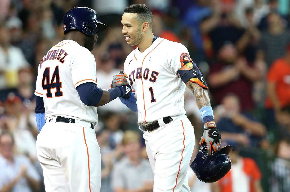 Houston Astros shortstop Carlos Correa (1) is congratulated by designated hitter Yordan Alvarez (44) after hitting a solo home run in the fourth inning at Minute Maid Park in Houston on Sunday, June 20, 2021.