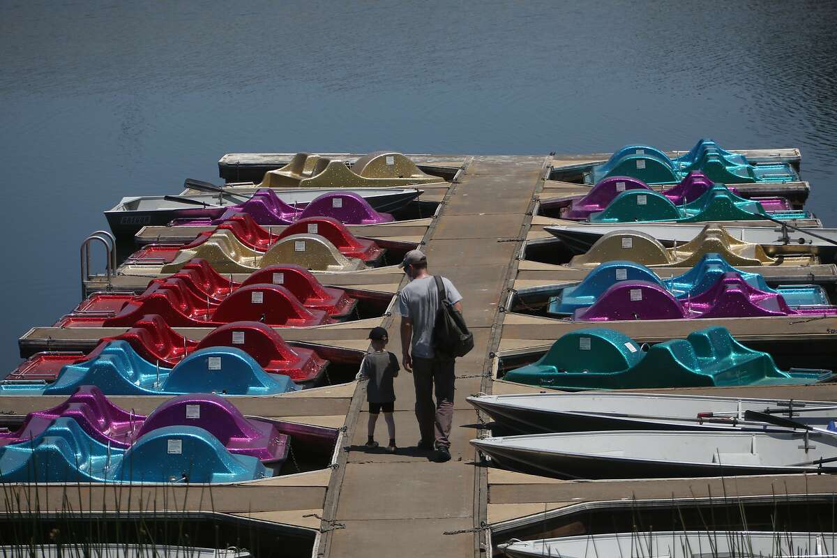 Simon Heron (right) and son James Heron (left), 4, walk on the dock as they choose a paddle boat to take out at the Lafayette Reservoir Recreation Area on June 18, 2021.