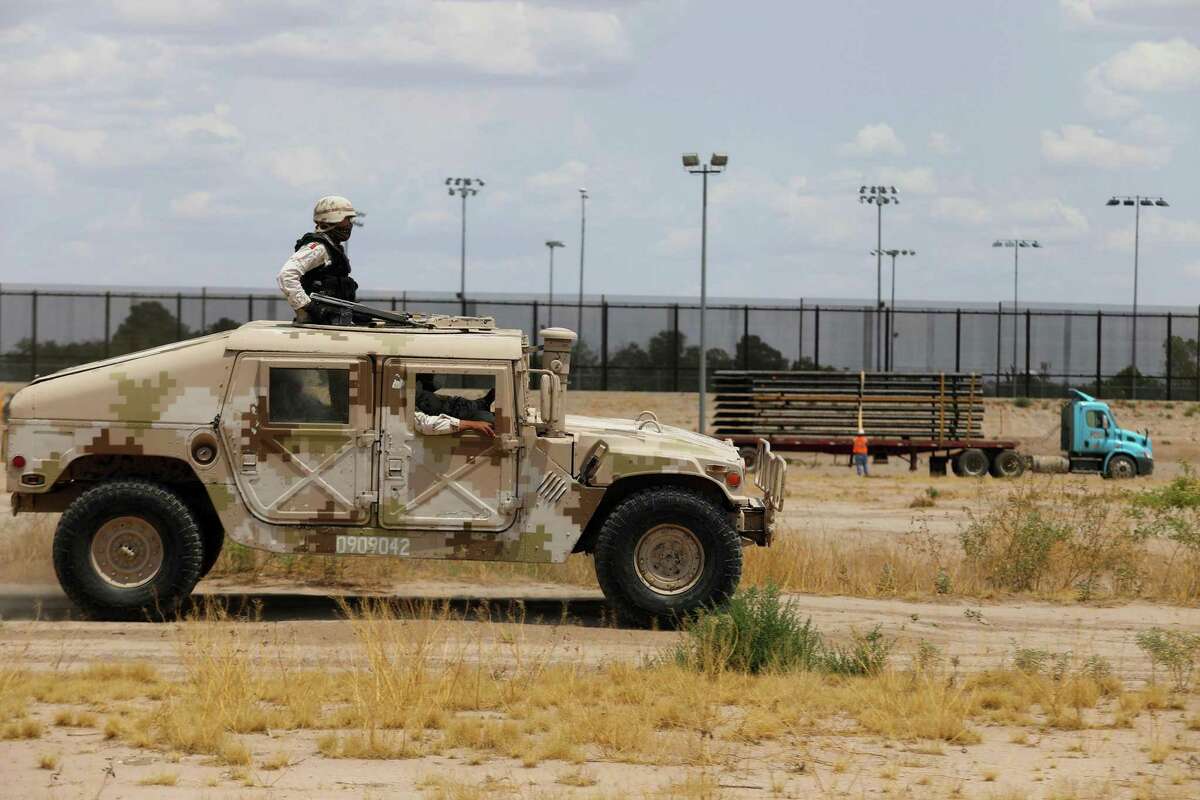 Members of the Mexican National Guard patrol along the Rio Grande, near the construction site of a new section of the border wall between El Paso, Texas, and Ciudad Juarez, Mexico, on Aug. 17, 2020. Texas Gov. Greg Abbott on Wednesday fleshed out his plan to erect a barrier along the state's border with Mexico and begin arresting migrants. (Herika Martinez/AFP via Getty Images/TNS)