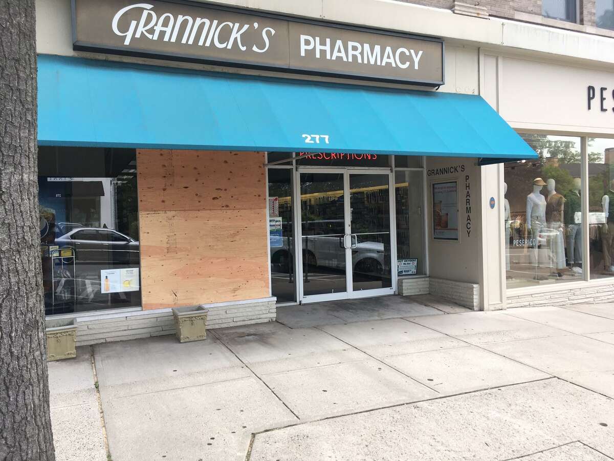 Plywood covered the damage left by intruders at two Greenwich Avenue pharmacies over the weekend.