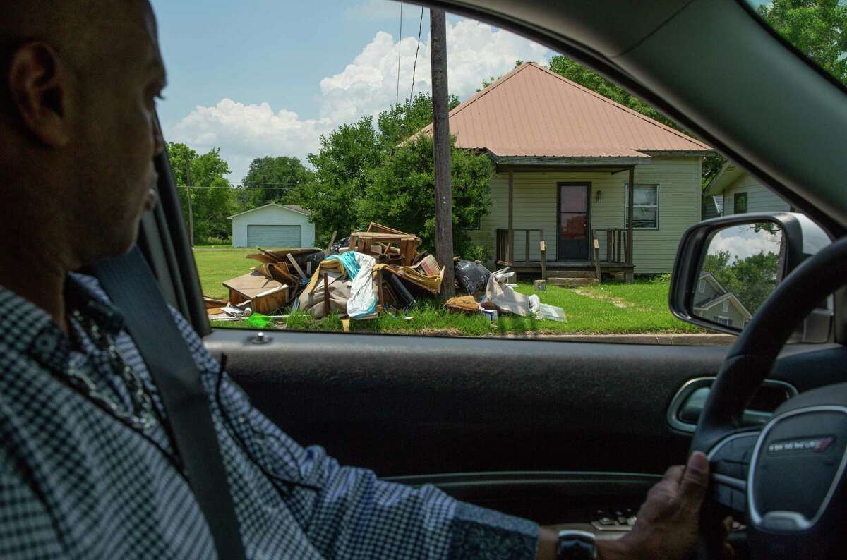 Port Arthur city employee Derrick Holland drives past a trash pile - which are common as people continue to deal with the aftermath of Hurricane Harvey and subsequent storms - on Tuesday, June 15, 2021, in Port Arthur.
