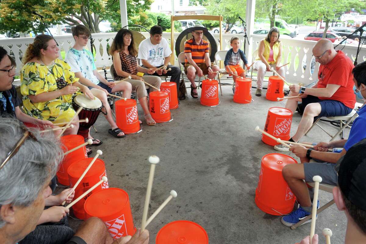 People gather at the gazebo on Sherman Green to take part in a utility bucket drum circle as part of Make Music Day, in Fairfield, Conn. June 21, 2021.