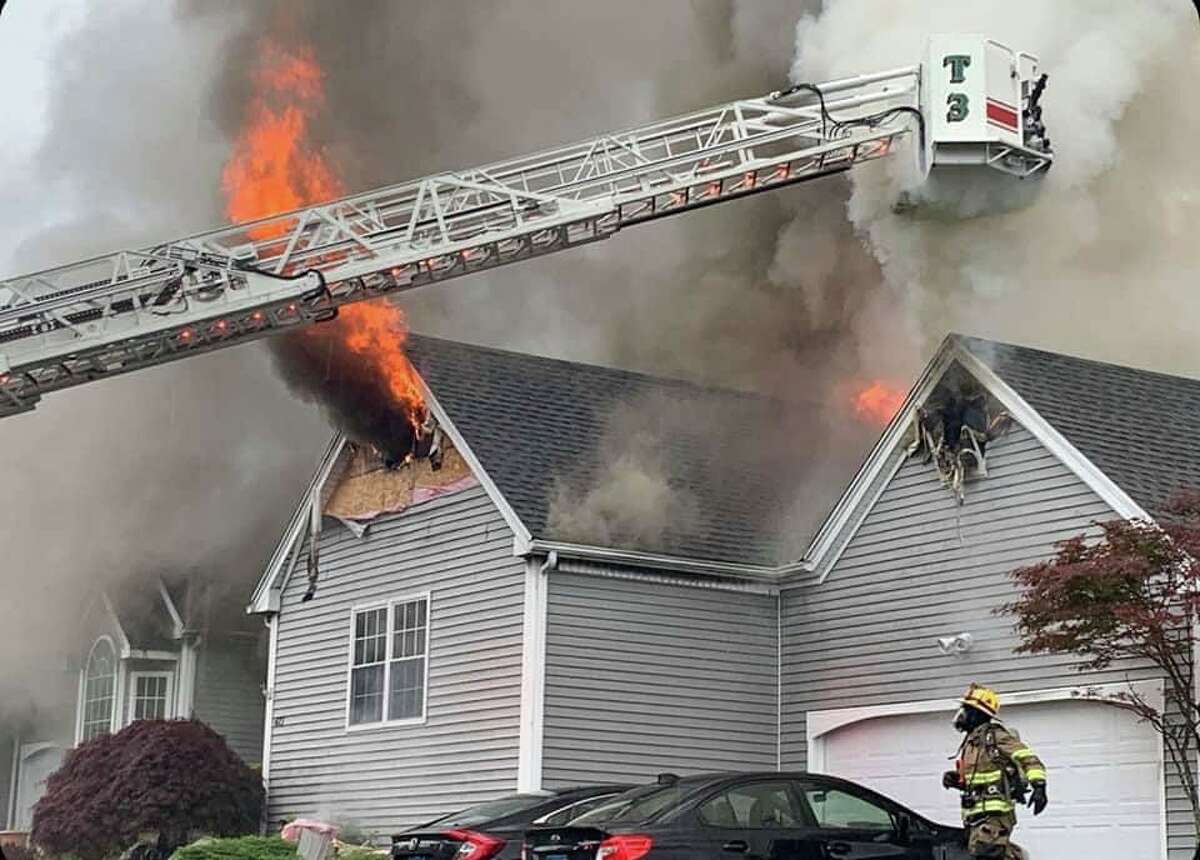 Firefighters battle a blaze at a Mica Court condo in Shelton, Conn., on Tuesday, June 22, 2021.