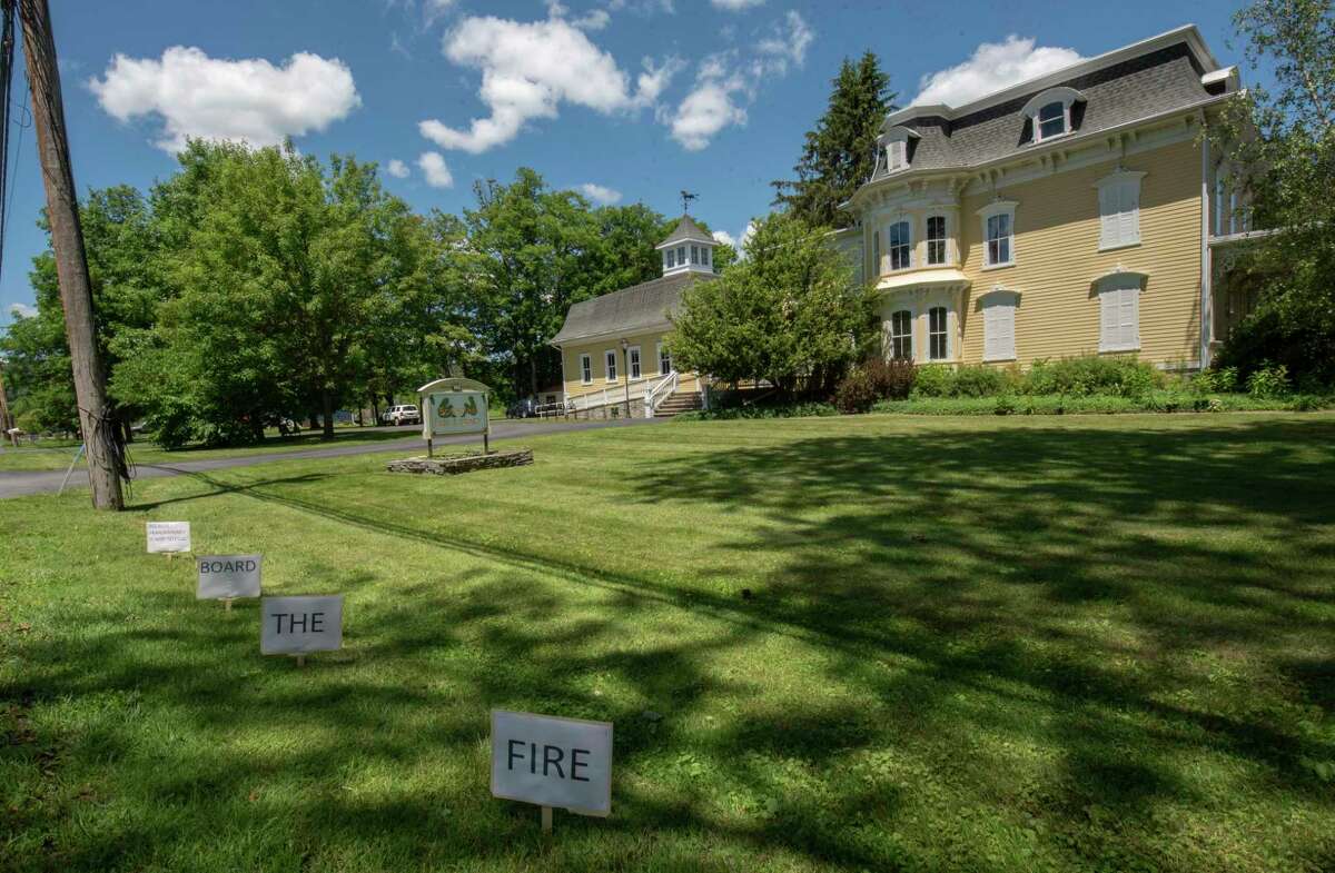 Signs reading ‘fire the board because transparency is not illegal’ line Bridge St. on the lawn of Schoharie Free Library on Wednesday, June 23, 2021 in Schoharie, N.Y. (Lori Van Buren/Times Union)