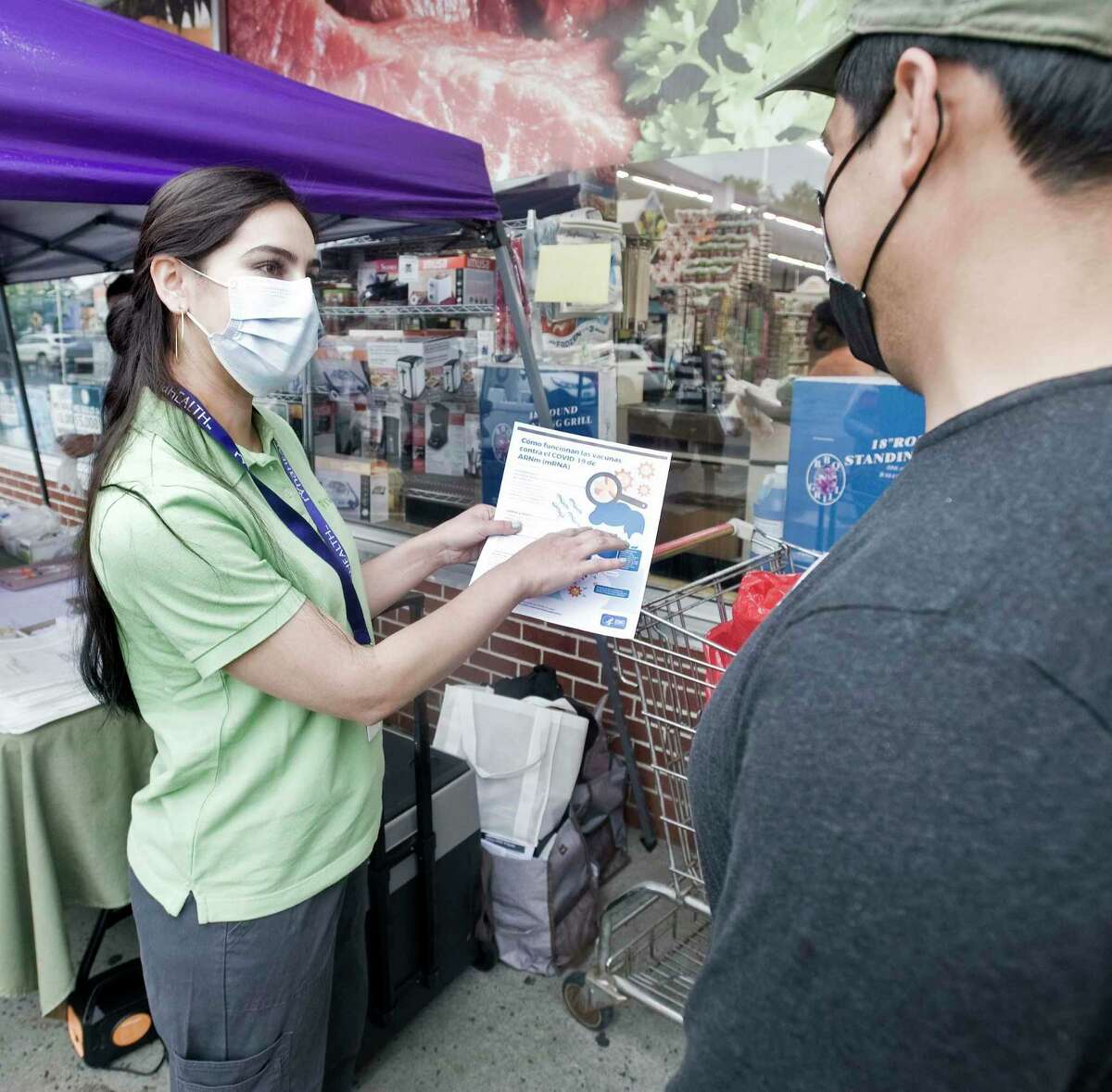 Jackie Felix, a nurse with the Ridgefield Visiting Nurse Association, explains COVID-19 vaccine information to Oscar Flores of Pawling, at CTown Supermarket in Danbury. Tuesday, June 22, 2021