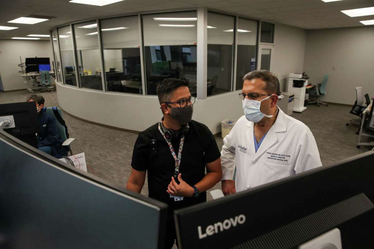 Jay Paul Bedruz, left, a nurse manager, and Dr. Faisal Masud, medical director of the center for critical care, talk in the virtual intensive care unit Wednesday, June 23, 2021, at Houston Methodist Hospital in Houston.