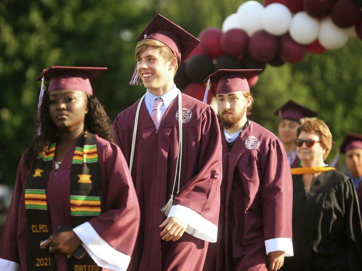 Happy graduates march in to the Bethel High School graduation ceremony at the school in Bethel, Conn. on Wednesday, June 23, 2021.