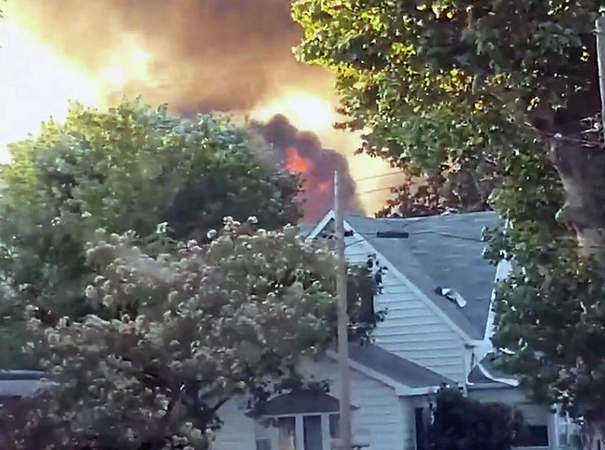 Flames leap above trees in a Meredosia neighborhood after an explosion and ensuing fire.