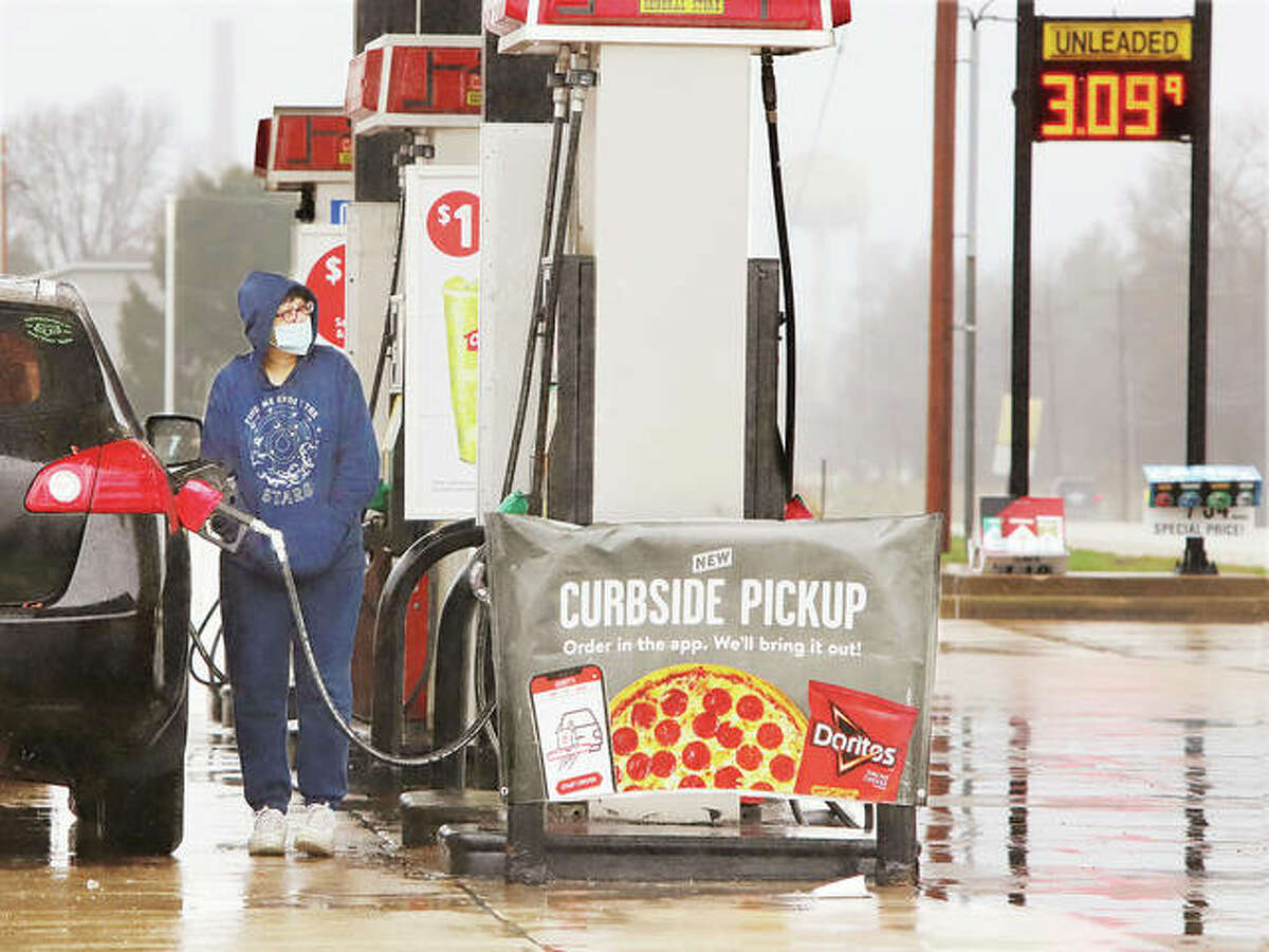 A customer of Casey’s General Store on Fosterburg Road in Alton pumps gas in this March photo. Illinois’ fuel taxes are set to rise July 1.