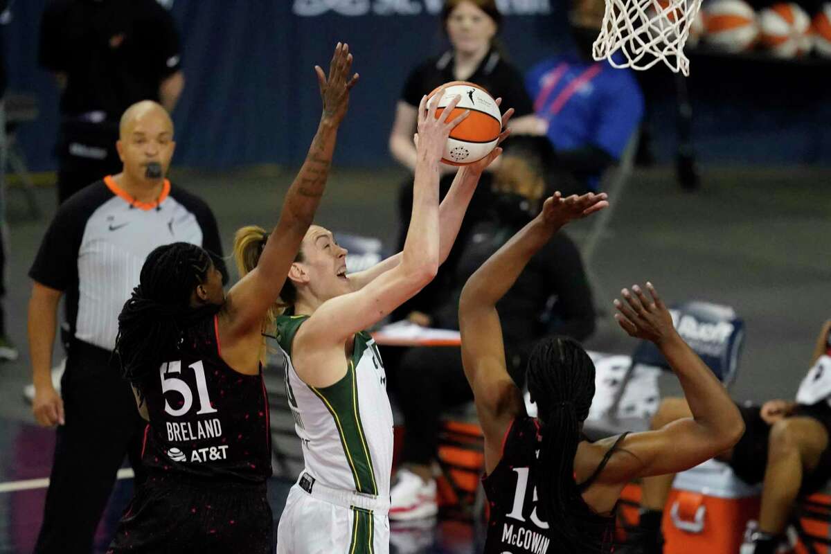 The Seattle Storm’s Breanna Stewart, second from left, shoots against the Indiana Fever’s Jessica Breland (51) and Teaira McCowan (15) during the first half on June 17.