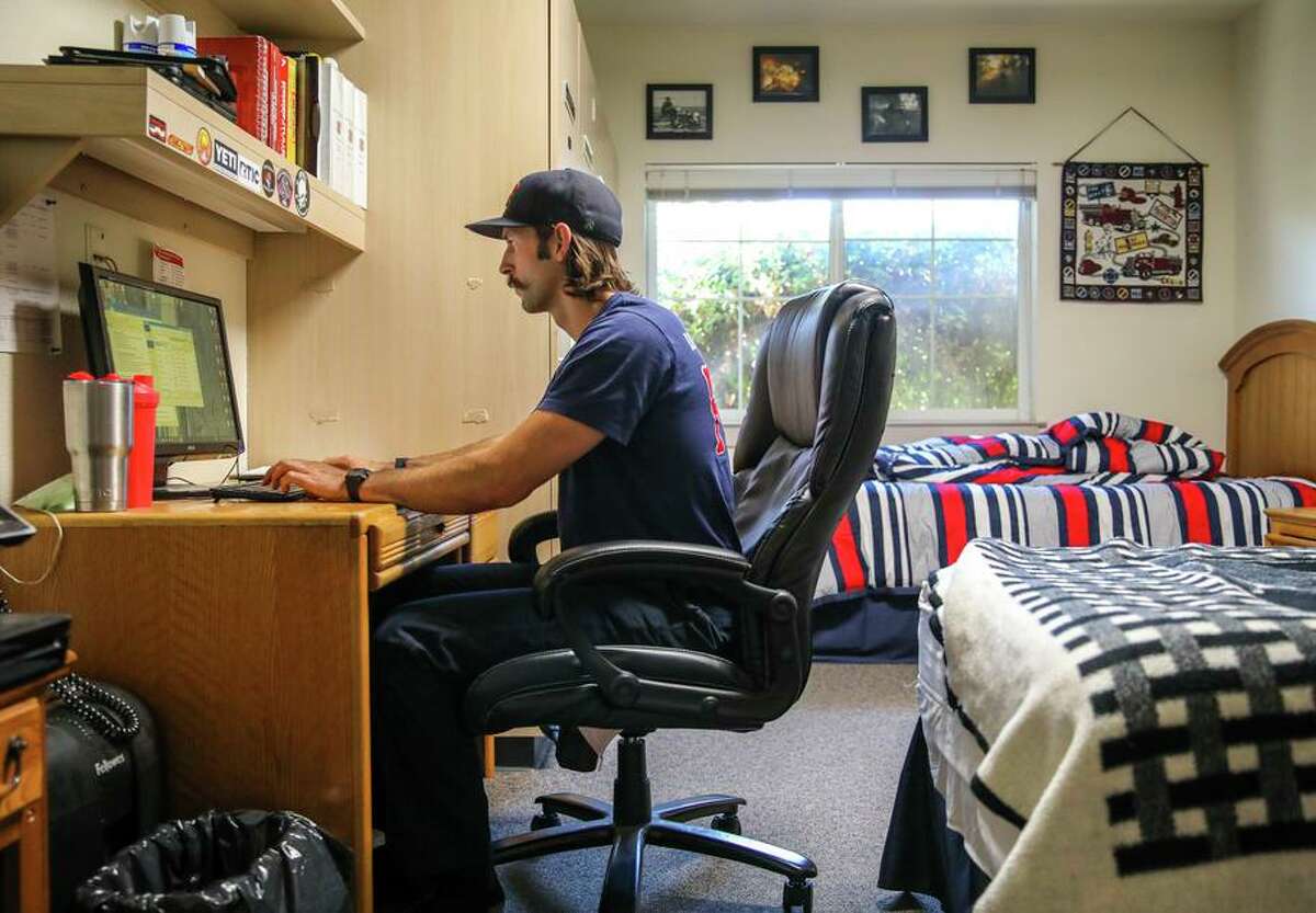 Jared Gavard, 31, of Orangevale, works at his desk at the East Contra Costa Fire Protection District, Station 52, located at 201 John Muir Parkway, on Thursday, June 17, 2021, in Brentwood, Calif. Development has caused the population to boom, which means it constantly pulls fire engines from other parts of the county to provide basic service.