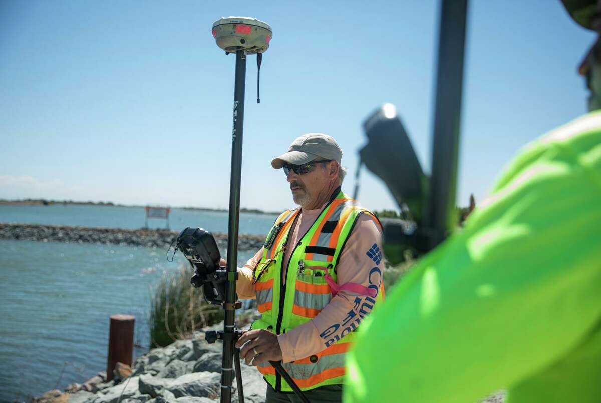 Scott Rebelo, a Department of Water Resources surveyor, takes measurements Thursday of the salinity barrier outside of Oakley.