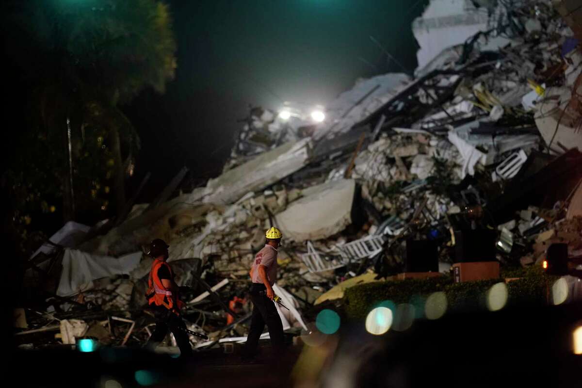 Rescue workers walk beside the rubble as rescue efforts continue where a wing of a 12-story beachfront condo building collapsed, Thursday, June 24, 2021, in the Surfside area of Miami.
