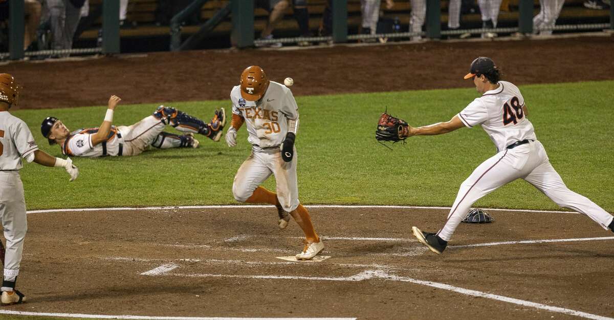 Texas outfielder Eric Kennedy (30) runs home on a wild pitch by Virginia pitcher Mike Vasil (48) during a baseball game in the College World Series Thursday, June 24, 2021, at TD Ameritrade Park in Omaha, Neb. (AP Photo/John Peterson)