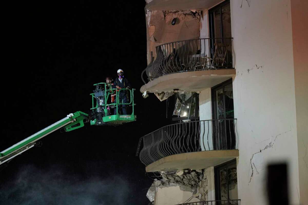 Workers use a lift to investigate balconies in the still-standing portion of the building, as rescue efforts continue where a wing of a 12-story beachfront condo building collapsed, late on Thursday, June 24, 2021, in the Surfside area of Miami.