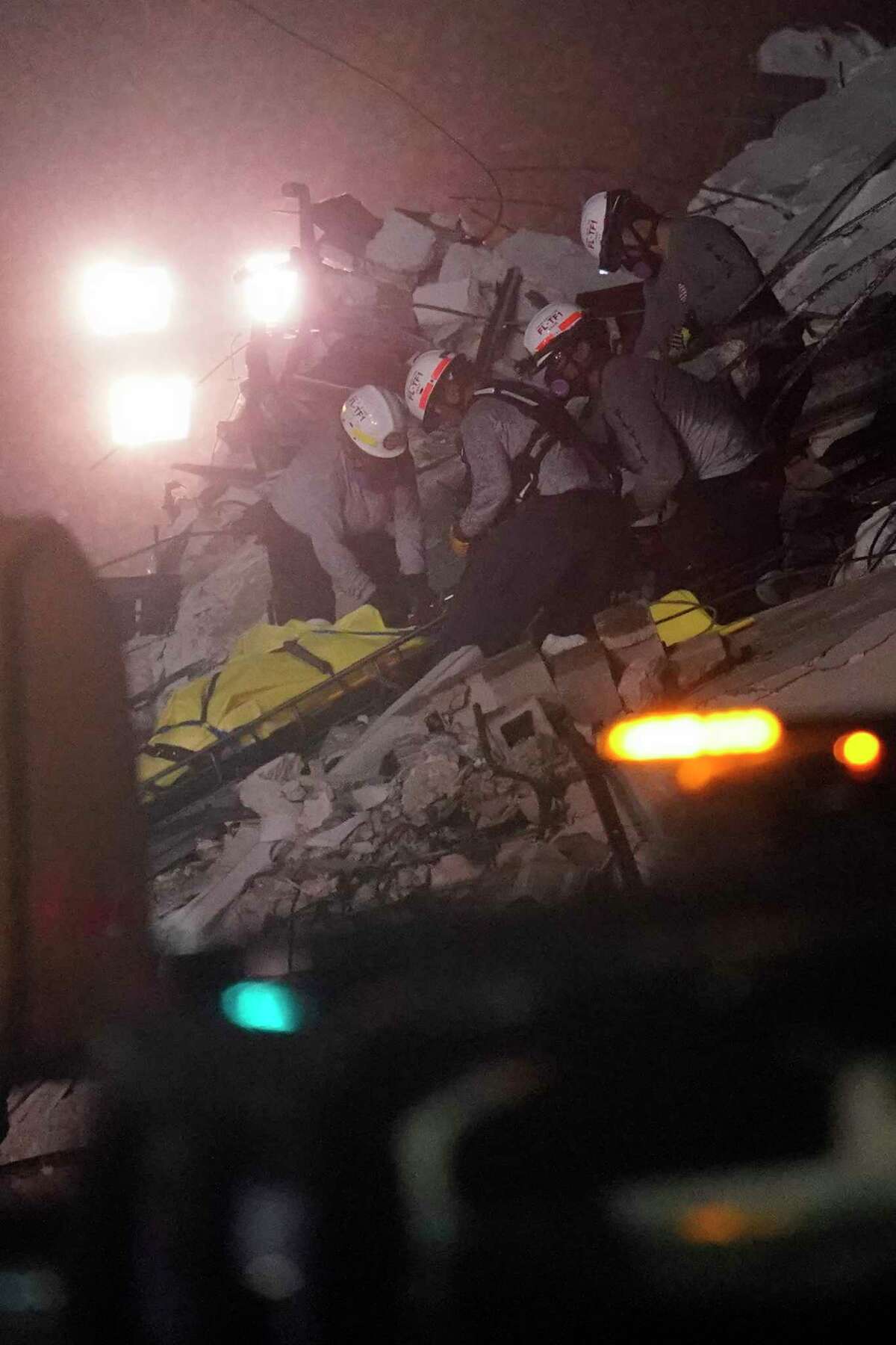 Rescue workers remove a body from the rubble where a wing of a 12-story beachfront condo building collapsed, Thursday, June 24, 2021, in the Surfside area of Miami.