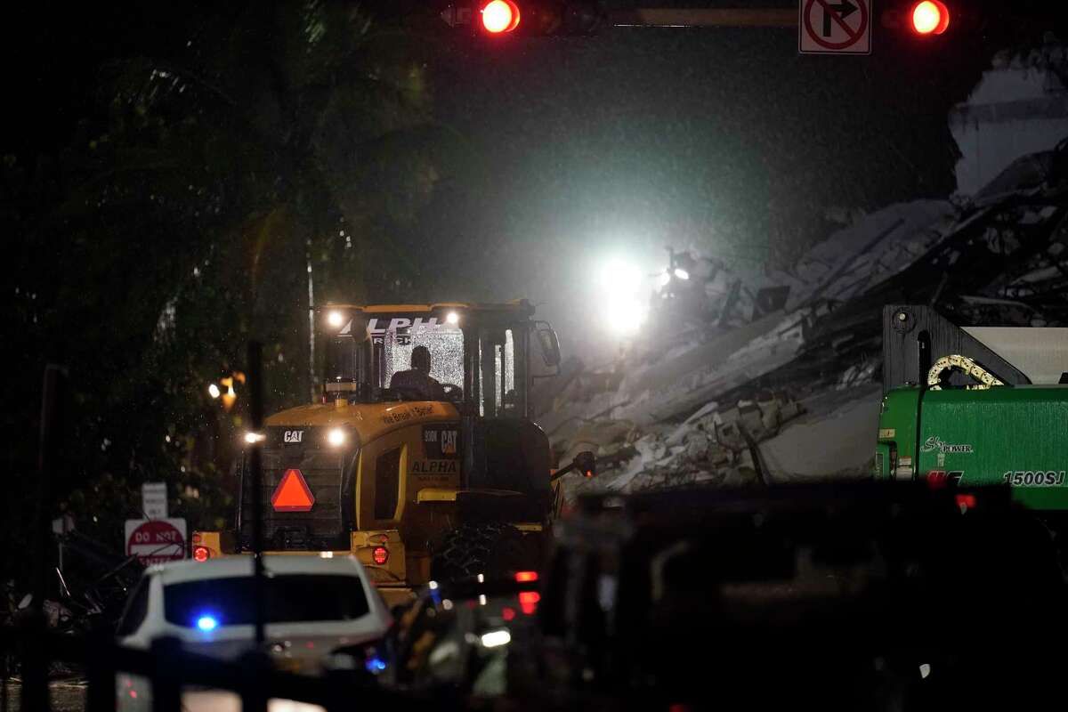 A driver uses an excavator to shift rubble as rescue efforts continue where a wing of a 12-story beachfront condo building collapsed, Thursday, June 24, 2021, in the Surfside area of Miami.