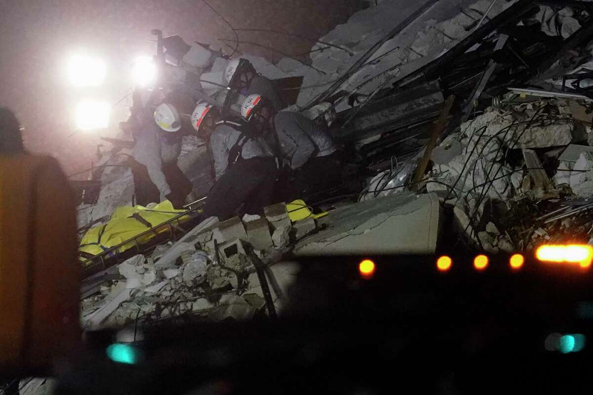 Rescue workers remove a body from the rubble where a wing of a 12-story beachfront condo building collapsed, Thursday, June 24, 2021, in the Surfside area of Miami.