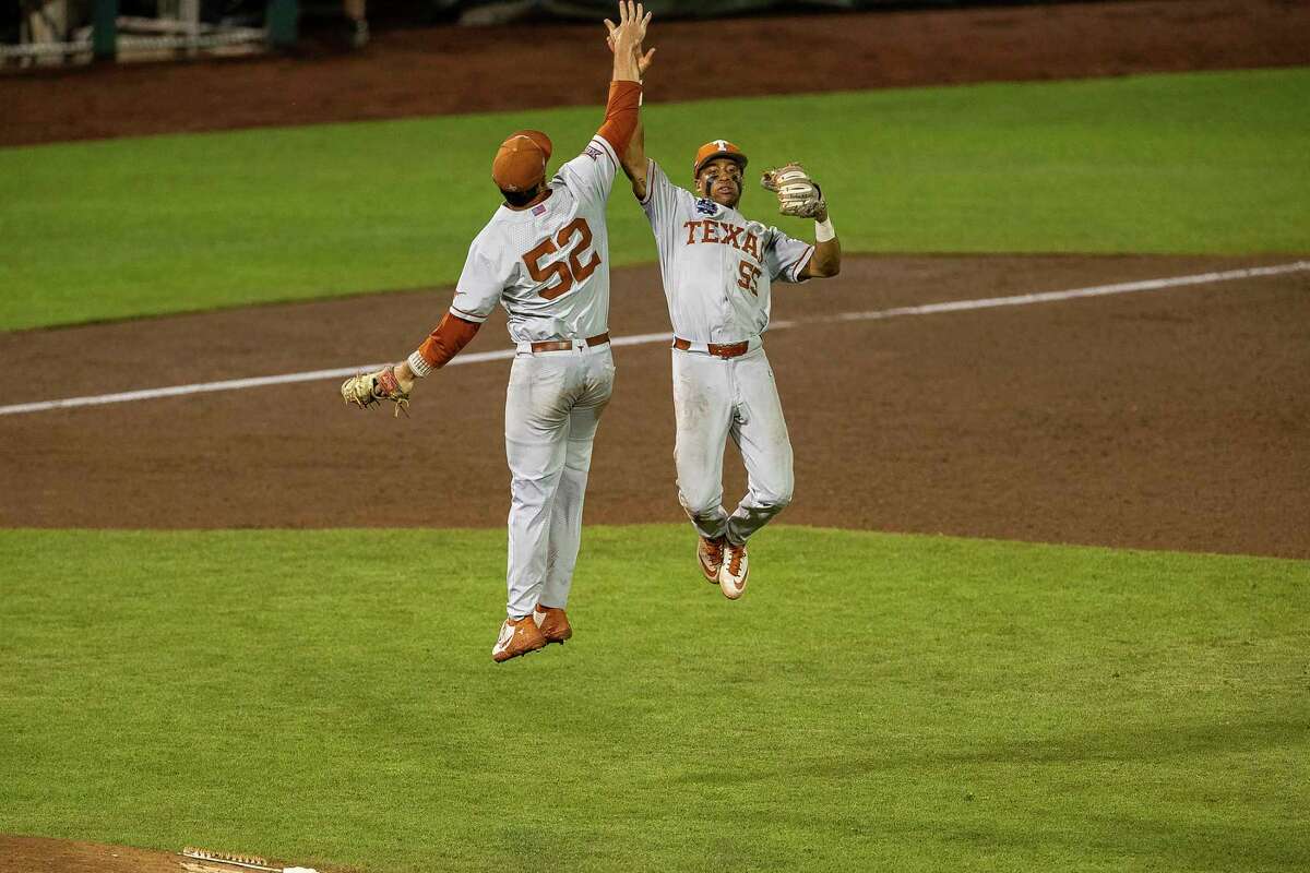 Texas' Camryn Williams (55) and Zach Zubia (52) give each other a high five celebrating their win over Virginia during a baseball game in the College World Series Thursday, June 24, 2021, at TD Ameritrade Park in Omaha, Neb. (AP Photo/John Peterson)