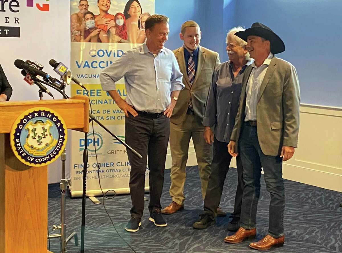 Gov. Ned Lamont chats with State Rep. Antonio Felipe, D-130, concert promoter Jim Koplik and Bridgeport Mayor Joseph Ganim during Friday’s announcement of the state’s Rock the Shot vaccination incentive program.