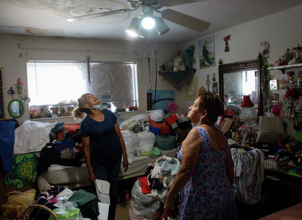 Corrina Jimenez, left, looks up at the rotten ceiling found in a room inside the apartment of Blanca Lydia Martinez, right, at Victoria Manor Apartments on Friday, June 18, 2021, in Houston. Several COVID-19 relief measures are set to end soon, including an eviction moratorium and unemployment benefits.