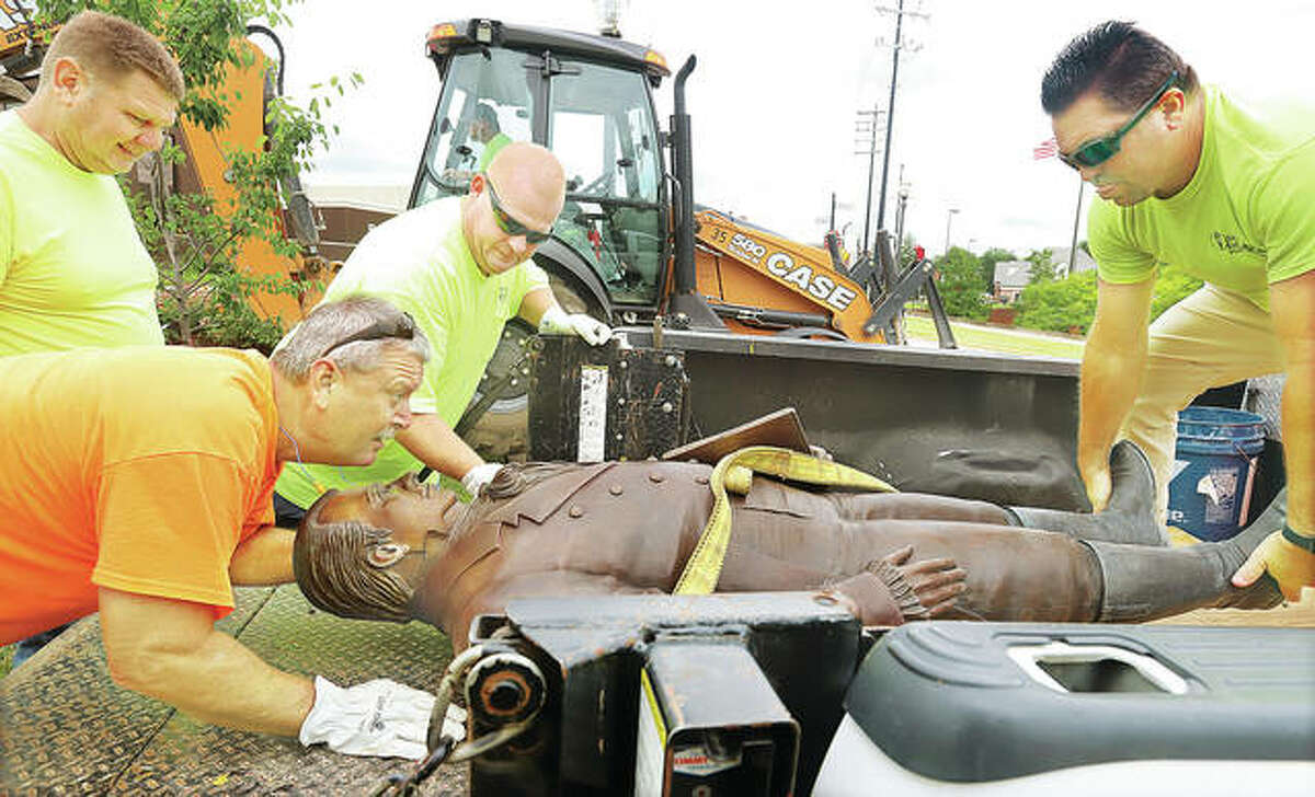 Edwardsville Public Works employees slide the controversial statue of Ninian Edwards, the founder of Edwardsville, into the back of a city truck after removing it from the small park it was in.