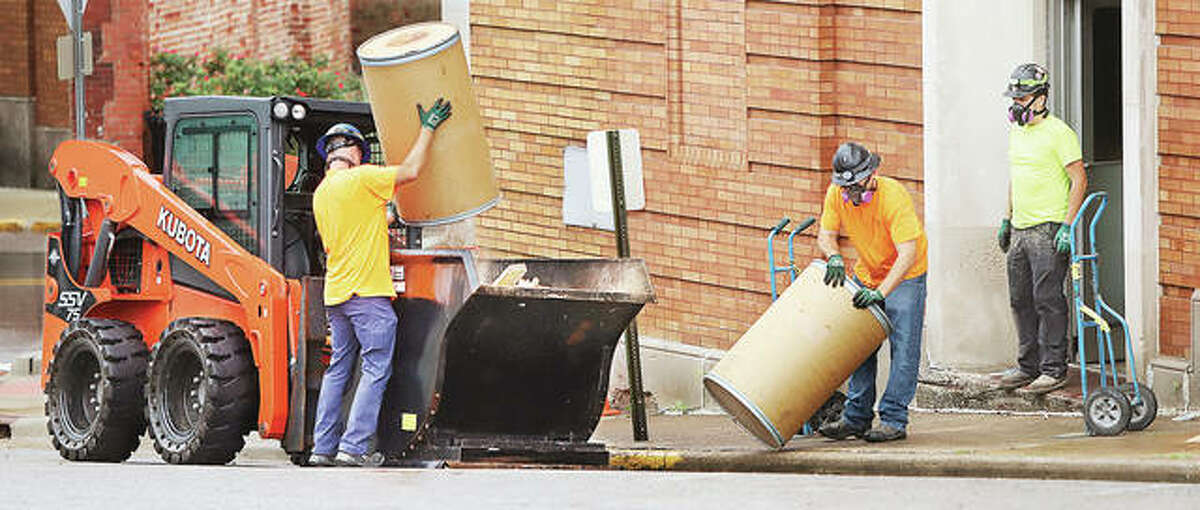 Workers dump building materials into a dumpster Friday while doing renovation work inside the Wedge Building in downtown Alton. Unemployment in the Metro East fell to 4.6 percent in May, according to the Illinois Department of Employment Security and U.S. Bureau of Labor Statistics.