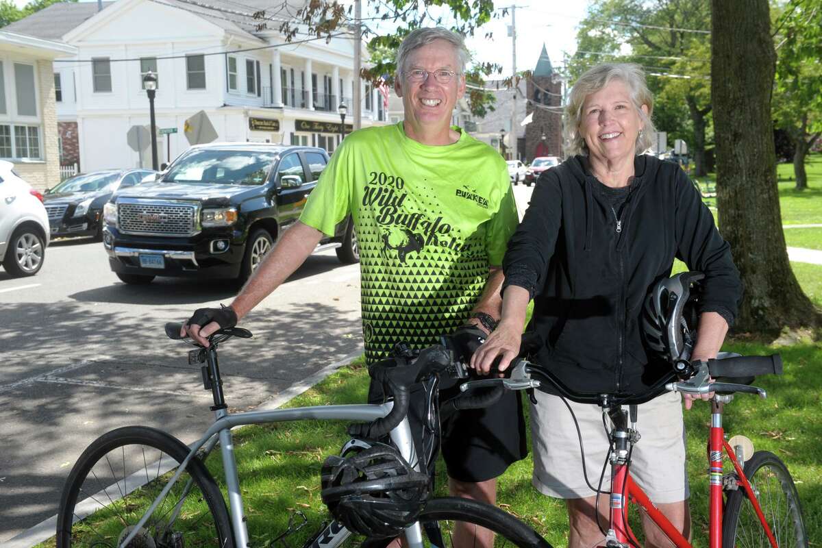 Steve and Patricia Hauser pose with their bicycles on the Milford Green, in Milford, Conn. June 23, 2021. The Hausers are part of a group of bicycle enthusiasts advocating for safe bicycle lanes around the city.
