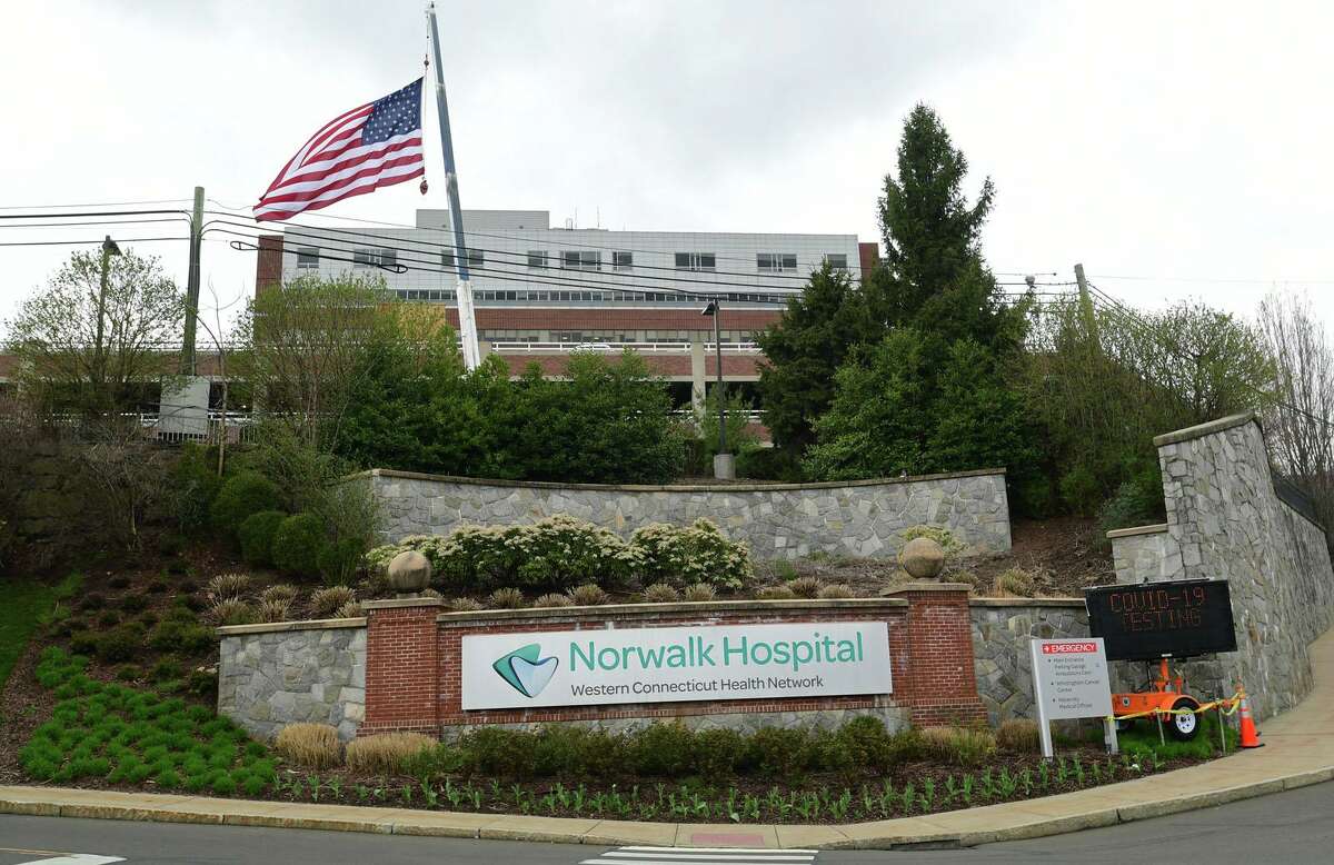 J&K Tree Service sets up a crane to display a large American Flag and a thank you note for Norwalk Hospital staff Wednesday, April 8, 2020, in Norwalk, Conn.