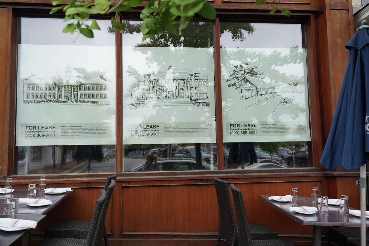 The former New Balance store at 28 Main Street has received six panels of the wallpaper designed to spruce up empty storefronts in the village of New Canaan. The picture was taken on June 25, 2021. The tables belong to Spiga restaurant next door.