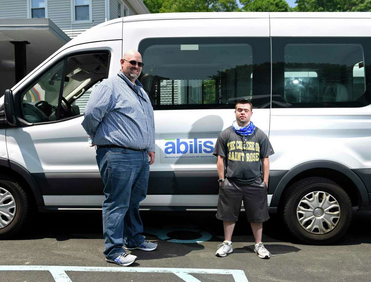 Abilis Director of Competitive Employment Matthew Miceli, left, and Abilis client Joe Lupinacci pose together at Abilis in the Glenville section of Greenwich, Conn. Wednesday, May 26, 2021. COVID-19 affected the employment rate for people with disabilities more so than those without disabilities. Lupinacci was furloughed from his job as an aquatics assistant at the New Canaan YMCA during the pandemic.