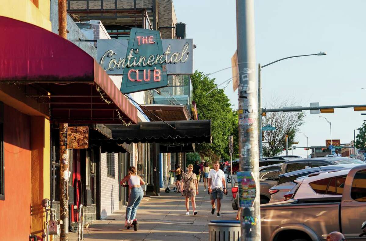 People walk and scoot down South Congress Avenue in Austin. The capital city is in a housing frenzy, partially driven by incoming Californians.