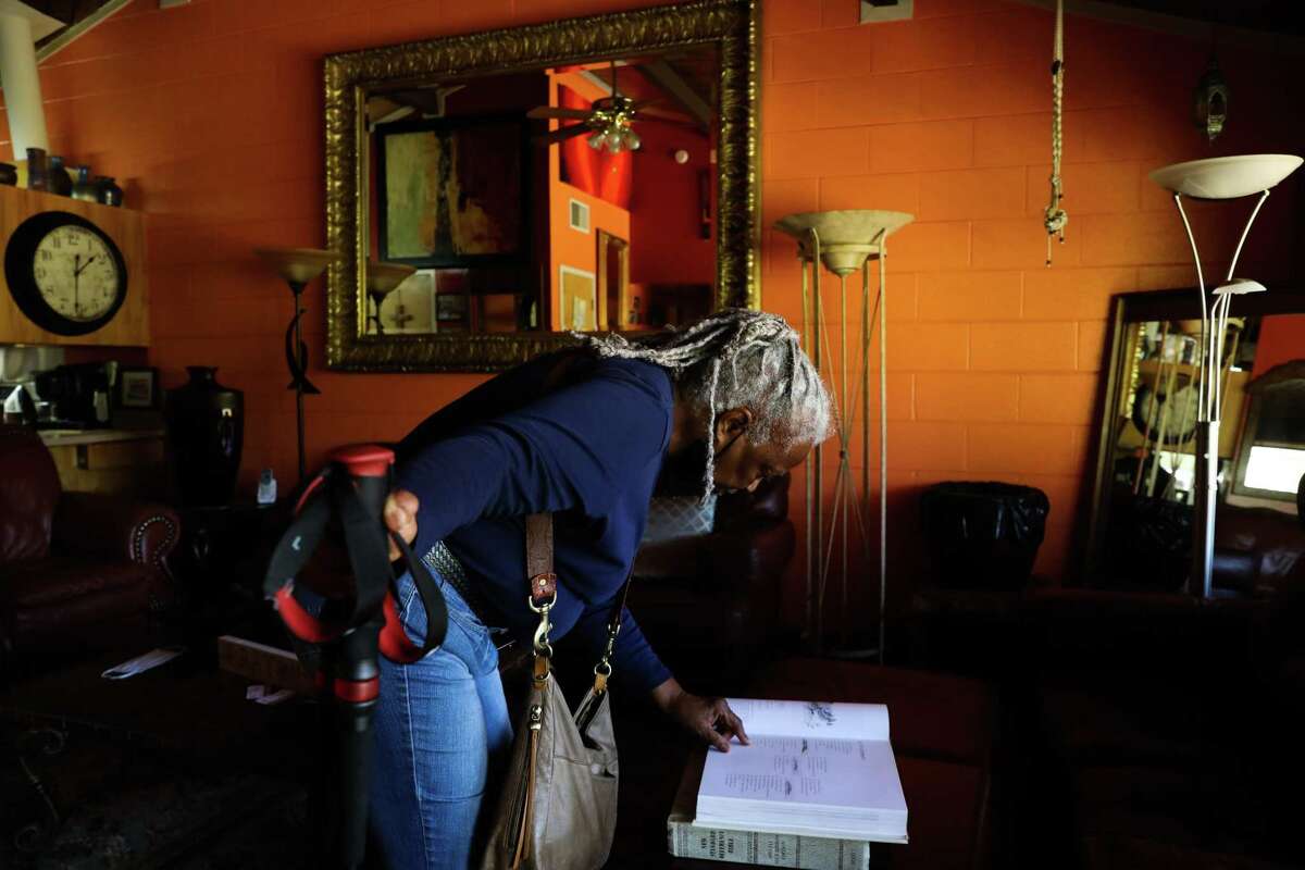 Longtime Golden Gate Village resident Royce McLemore looks at an architecture book in her Golden Gate Village apartment. McLemore has led a call for the county to address the property’s maintenance issues.