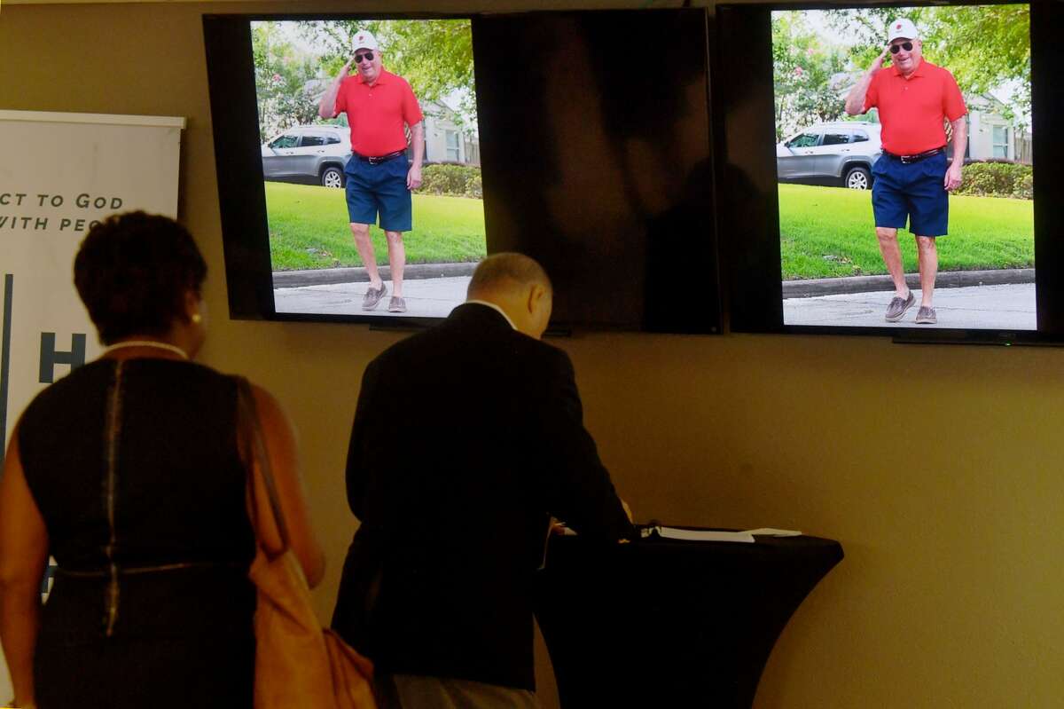 Service attendees sign the guest book as photos play overhead during the funeral service for W.L. Pate at One City Church Friday. Photo made Friday, June 25, 2021 Kim Brent/The Enterprise