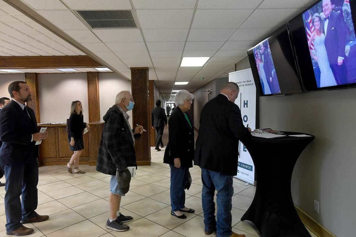 Service attendees sign the guest book as photos play overhead during the funeral service for W.L. Pate at One City Church Friday. Photo made Friday, June 25, 2021 Kim Brent/The Enterprise