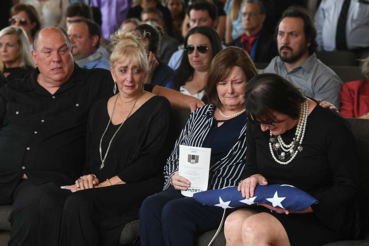Jennifer Pate is consoled by her mother Martha Brown Pate as her uncle Robert and aunt Sandy look on after she was presented with her father's flag during the funeral service for W.L. Pate at One City Church Friday. Photo made Friday, June 25, 2021 Kim Brent/The Enterprise