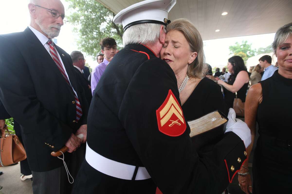 Sherrene Danks-Cook is comforted by an officer as Lamar President Ken Evans waits to offer his condolences during the funeral service for W.L. Pate at One City Church Friday. Photo made Friday, June 25, 2021 Kim Brent/The Enterprise