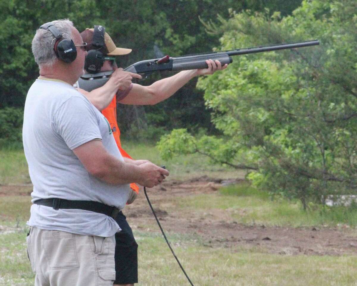 Doug Walls (left) of Baldwin watches as his son works out at the Lake County Sportsman Club trap field on Saturday. (Star photo/John Raffel)
