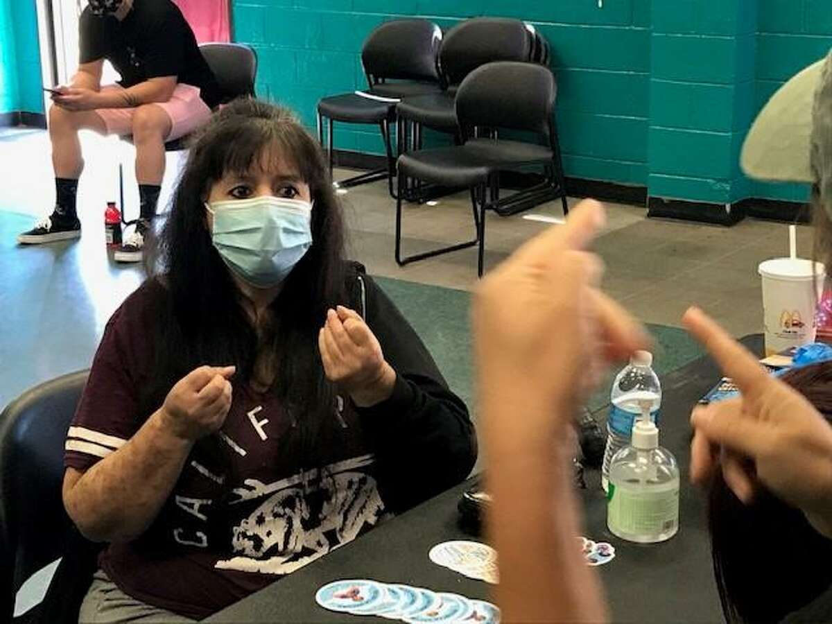 Jacqueline Augustine, who is deaf, communicates to a nurse through a sign language interpreter at a pop-up clinic in San Leandro.