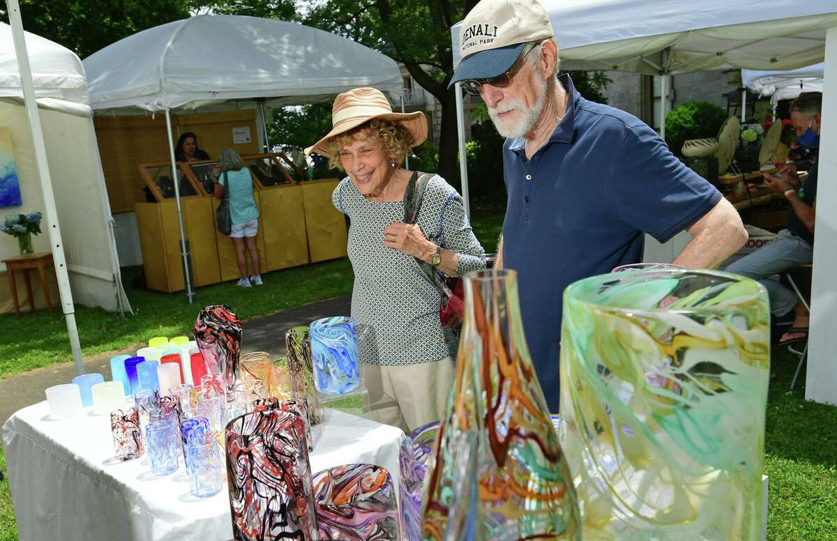 Jerry and Roni Liebowitza looka glasswares from artist Jason Curtis during The Norwalk Art Festival Saturday, June 26, 2021, at Mathews Park in Norwalk, Conn. The festival which continues Sunday features the works of 100 juried artists exhibiting a wide variety of media including, photography, drawing, ceramics, jewelry, painting, mixed media, printmaking, fiber, metal sculpture and glass. The Center for Contemporary Printmaking, Stepping Stones Museum, Mathews Mansion Museum and The Norwalk Parks Department, sponsored the festival.