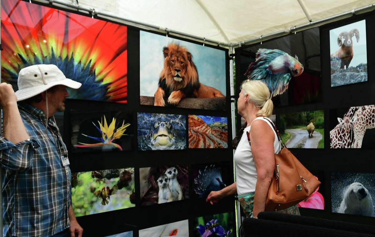 Bruce Franklin greets Norwalk resident Dawn Del Greco as she looks at his work during the Norwalk Art Festival on Saturday at Mathews Park in Norwalk. The festival which continues Sunday, features the works of 100 juried artists exhibiting a wide variety of media including, photography, drawing, ceramics, jewelry, painting, mixed media, printmaking, fiber, metal sculpture and glass. The Center for Contemporary Printmaking, Stepping Stones Museum, Mathews Mansion Museum and The Norwalk Parks Department sponsored the festival.