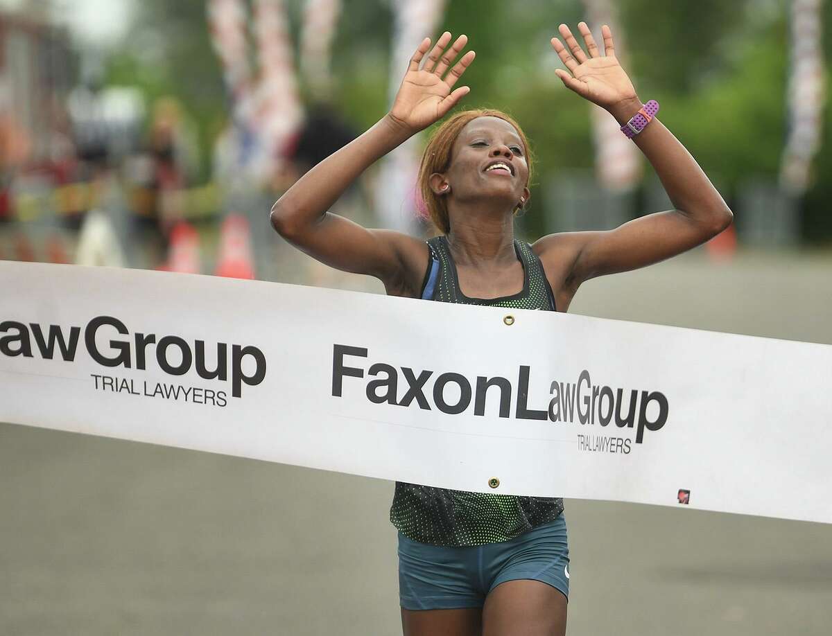 Monicah Ngige, of Lansing, MI, breaks the tape to win the Fairfield Half Marathon.